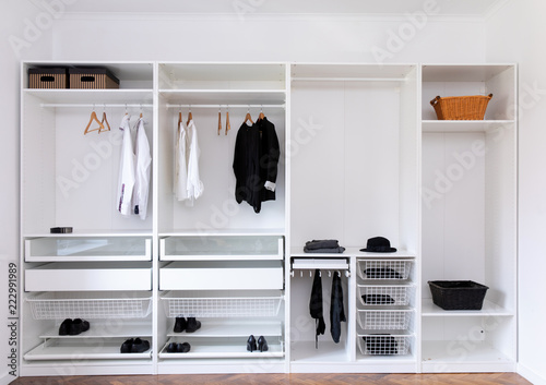 clothes hanging on rail in white wardrobe 