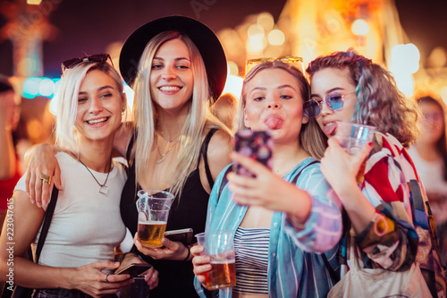 Group of female friends taking selfie at music festival 