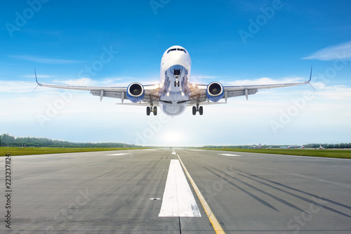 Passenger airplane landing at in good clear weather with a blue sky clouds on a runway.