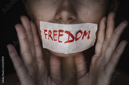 Concept of freedom speech: mouth of a person is sealed with an adhesive tape, closeup