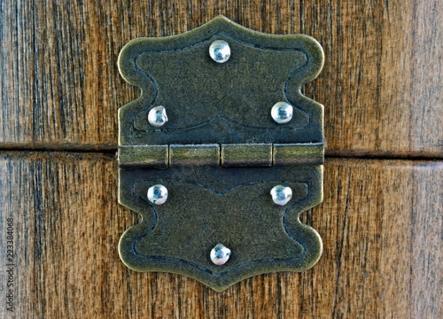 Old dusty rustic hinge on wooden box background 