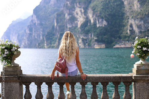 Bella ragazza giovane sta guardando bel paesaggio al Lago di Garda Foto fato a Riva del Garda, Italia. Beautiful young girl is looking at beautiful landscape at Lake Garda. Riva del Garda, Italy.