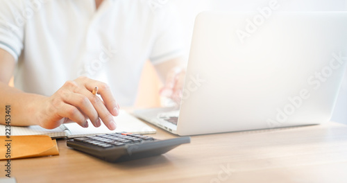 close up accountant business man writing cost estimate and pressing on calculator at office desk concept