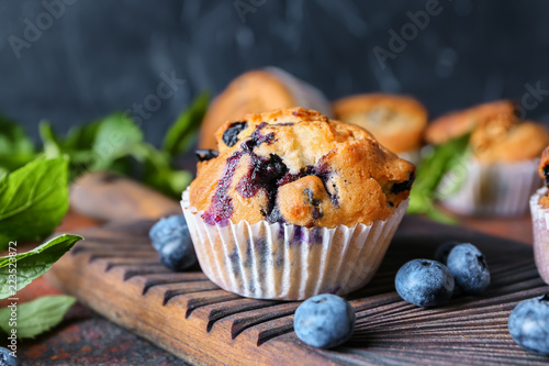 Tasty blueberry muffin on wooden board