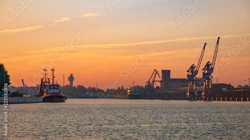 Ships in port at estuary of Vistula river at sunset time.