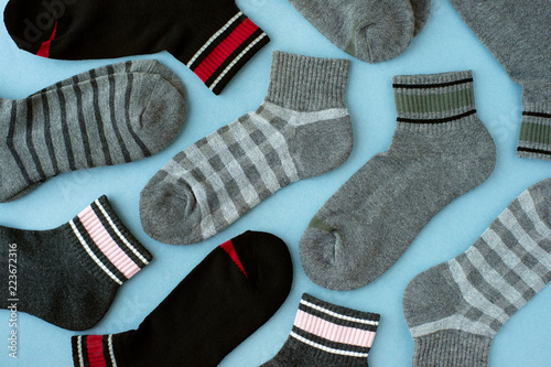 Gray socks on a blue background. View from above. Warm clothing for the feet in the form of socks. Many socks are scattered on the table.