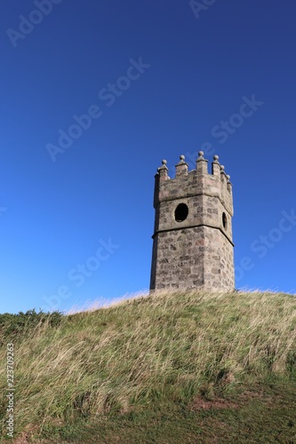 Old dovecot on hill against blue sky