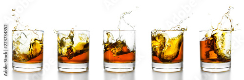 Scotch glasses with whiskey splashing from them
