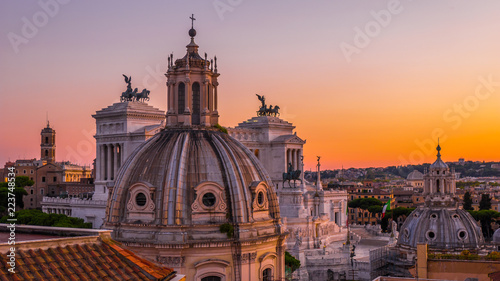 Beautiful sunset in Rome in orange, pink, purple and purple colors – a view of the landmarks and ancient architecture in the city center from the roof of the historic building