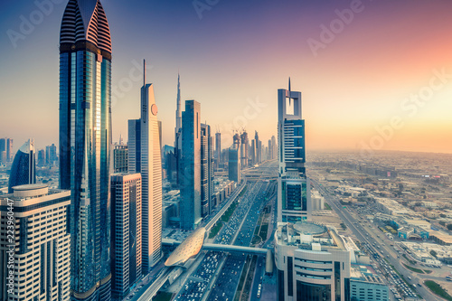 Skyscrapers and highways of a big modern city at sunset. Aerial view on downtown Dubai, United Arab Emirates.