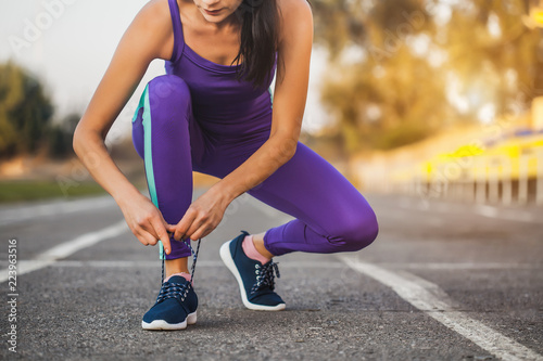 woman athlete tying shoelaces on sneakers.