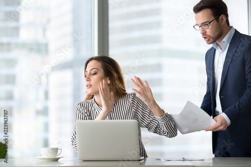 Tired bothered businesswoman abstracting from work refuse accept or consider report, annoyed female ceo gesturing rejecting mad business client or subordinate not looking at papers or documents