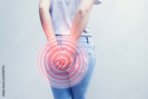 Woman hand holding her bottom because having Abdominal pain and Hemorrhoids, Health care concept.