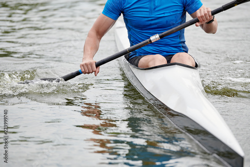 Close-up of kayaker holding paddle and rowing on the lake