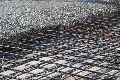 pouring concrete into prepared place with reinforced metal frame