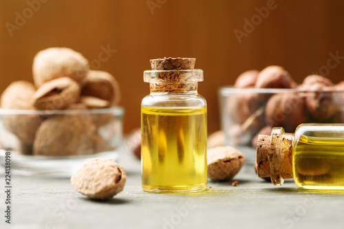 Almond and hazelnut in glass bowls with bright oil in small vial with wooden cork