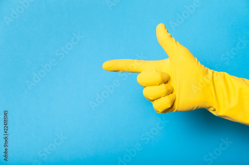 Hand in clean yellow glove, bathroom. Copy space for text.