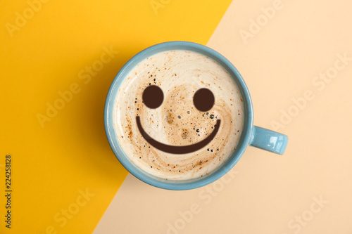 Cup of aromatic hot coffee on color background, top view