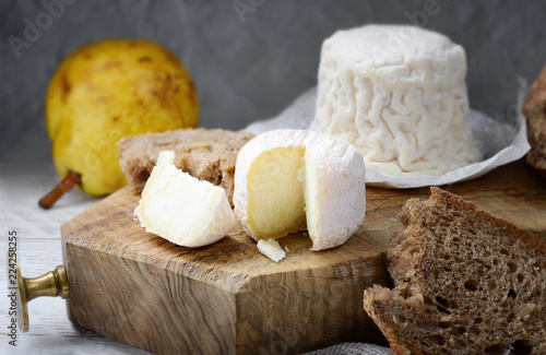 Crottin de Chavignol, French goat cheese on chopping board.