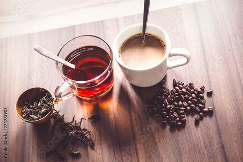 Coffee and tea with coffee bean and tea leaves on wooden floor.