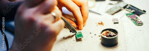 Image of engineer with soldering iron repairing mechanism