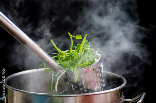 Noodle blanched in basket with hot smoke and steam.