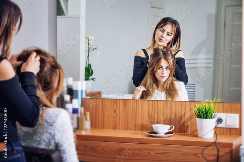 Young beautiful woman client makes a haircut and styling at a professional hairdresser in a beauty salon
