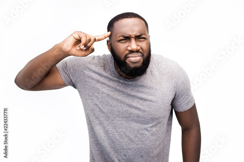 Why is that. Are you stuped? Angry agressive male half-length portrait isolated on trendy white studio backgroud. Young emotional, frustrated and bewildered man. Human emotions, facial expression