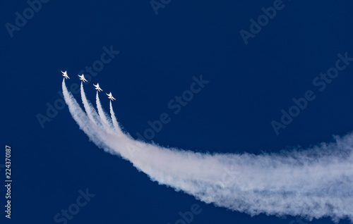 Sweeping jets into the blue sky with smoke trail