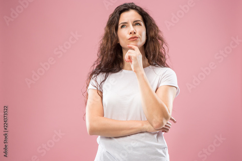 Remember all. Let me think. Doubt concept. Doubtful, thoughtful woman remembering something. Young emotional woman. Human emotions, facial expression concept. Studio. Isolated on trendy pink. Front