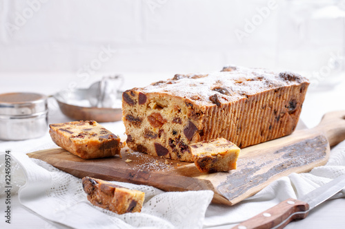 Traditional Christmas cake with fruits and nuts on white table