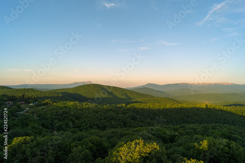 Wooded mountains at sunset in summer evening