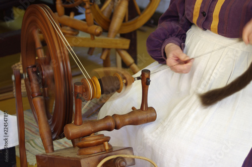 Pioneer lady using Old fashioned wooden spinning wheel 