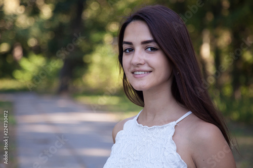 pretty young girl smiling in the park at sunset