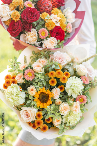 bright and delicate, two beautiful bouquet. Young girl holding a flowers arrangements with variety of colors. Bright dawn or sunset sun