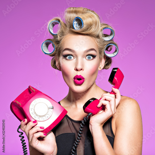 young woman with wonder face holds retro phone
