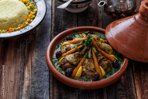 Morrocan dish chicken tajine on wooden table, copy space