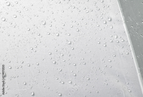 Water drops on waterproof fabric background. Raindrops on white umbrella.