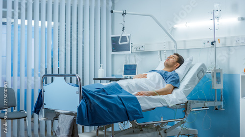 Sick Male Patient Lying on a Bed in the Private Ward in Hospital. White, Clean Environment.