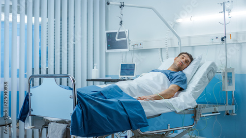 Sick Male Patient Lying on a Bed in the Private Ward in Hospital. White, Clean Environment.