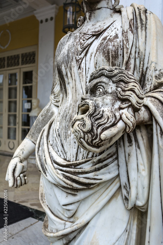 A tragic mask in the hand of Statue of Melpomene, the muse of tragedy, on the balcony of Achillion palace on greek island Corfu in Greece.