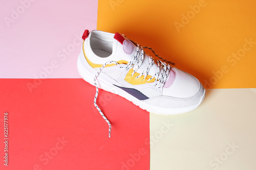 Single new stylish sneaker on color background