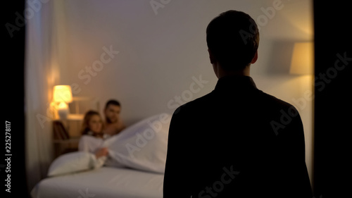 Man looking at his wife with lover in bed, unfair relations, partner cheating