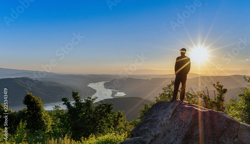 Hiker standing on a rock over a river