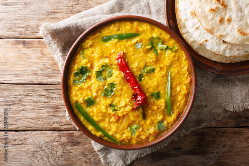 Indian popular food Dal Tadka Curry served with roti flatbread close-up. Horizontal top view