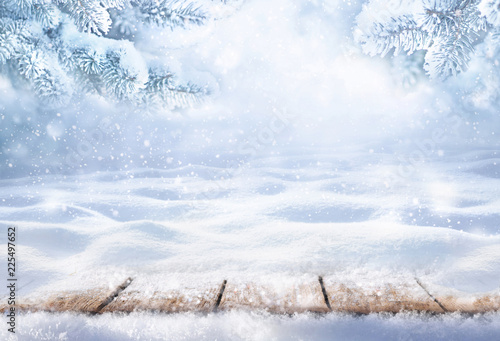 Winter christmas scenic background with copy space. Wooden flooring was strewn with snow in forest and branches of fir-trees covered with snow on the nature.