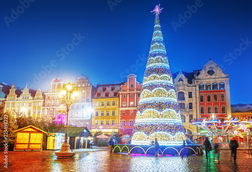 Wroclaw, Poland, Christmas market square and illuminated Christmas tree in the center of old city. New Year ambiance, illuminated and ornamented festive city. Night scene.