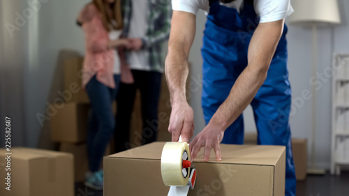 Couple sadly watching worker taking away their things, confiscation of property