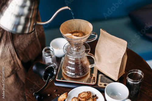 Hand drip coffee kit, barista pouring water on coffee ground with filter