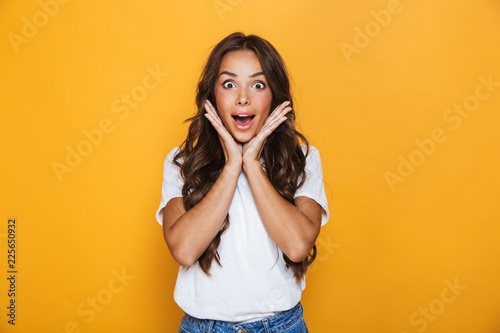 Emotional young pretty woman posing isolated over yellow background.